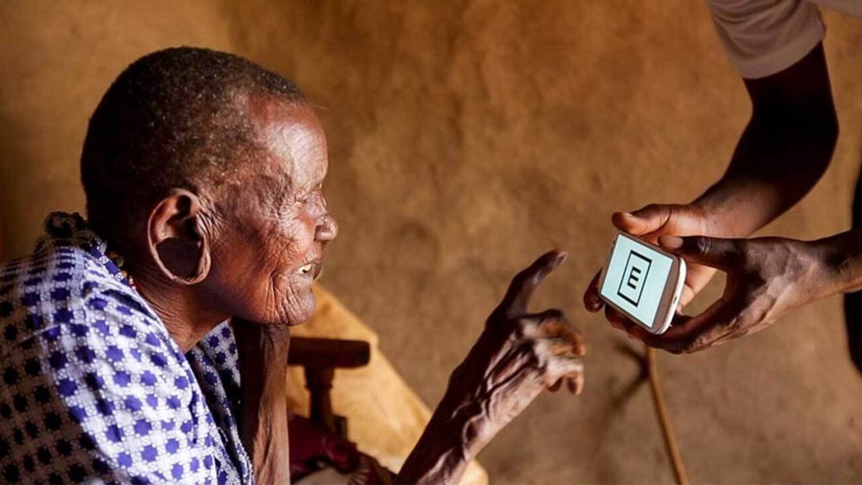 An older woman having her eyesight tested via a mobile phone app